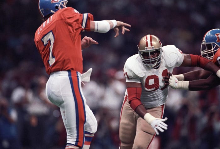 Denver Broncos quarterback John Elway (7) in action against San Francisco 49ers defensive end Larry Roberts (91) during Super Bowl XXIV at the Superdome. The 49ers defeated the Broncos 55-10.